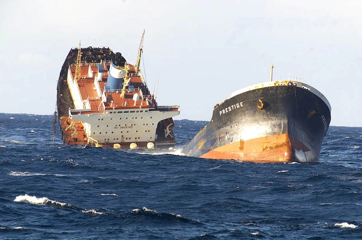 The Prestige oil tanker breaking apart in rough seas before sinking off the coast of Galicia in November 2002, leading to a major environmental disaster.