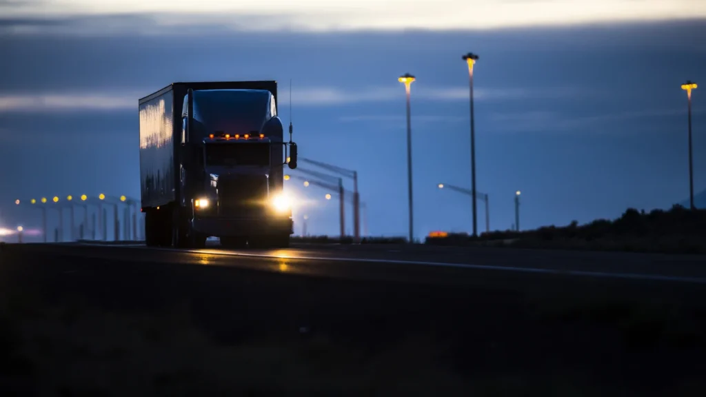 A Truck Driving on a Highway at Dusk