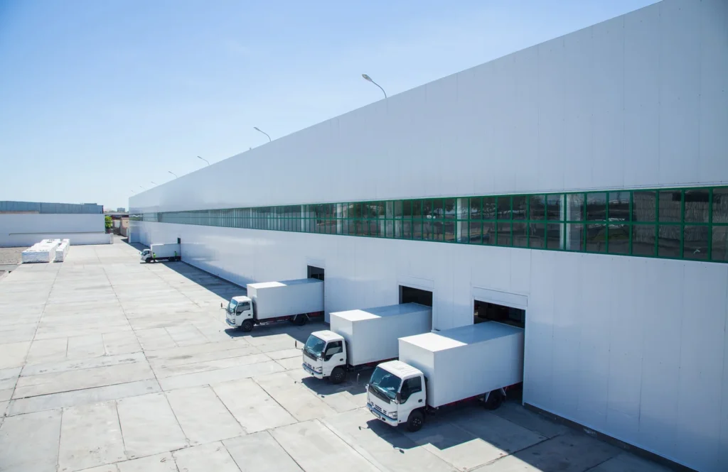 Freight forwarding warehouse with loading docks and trucks ready for cargo transportation