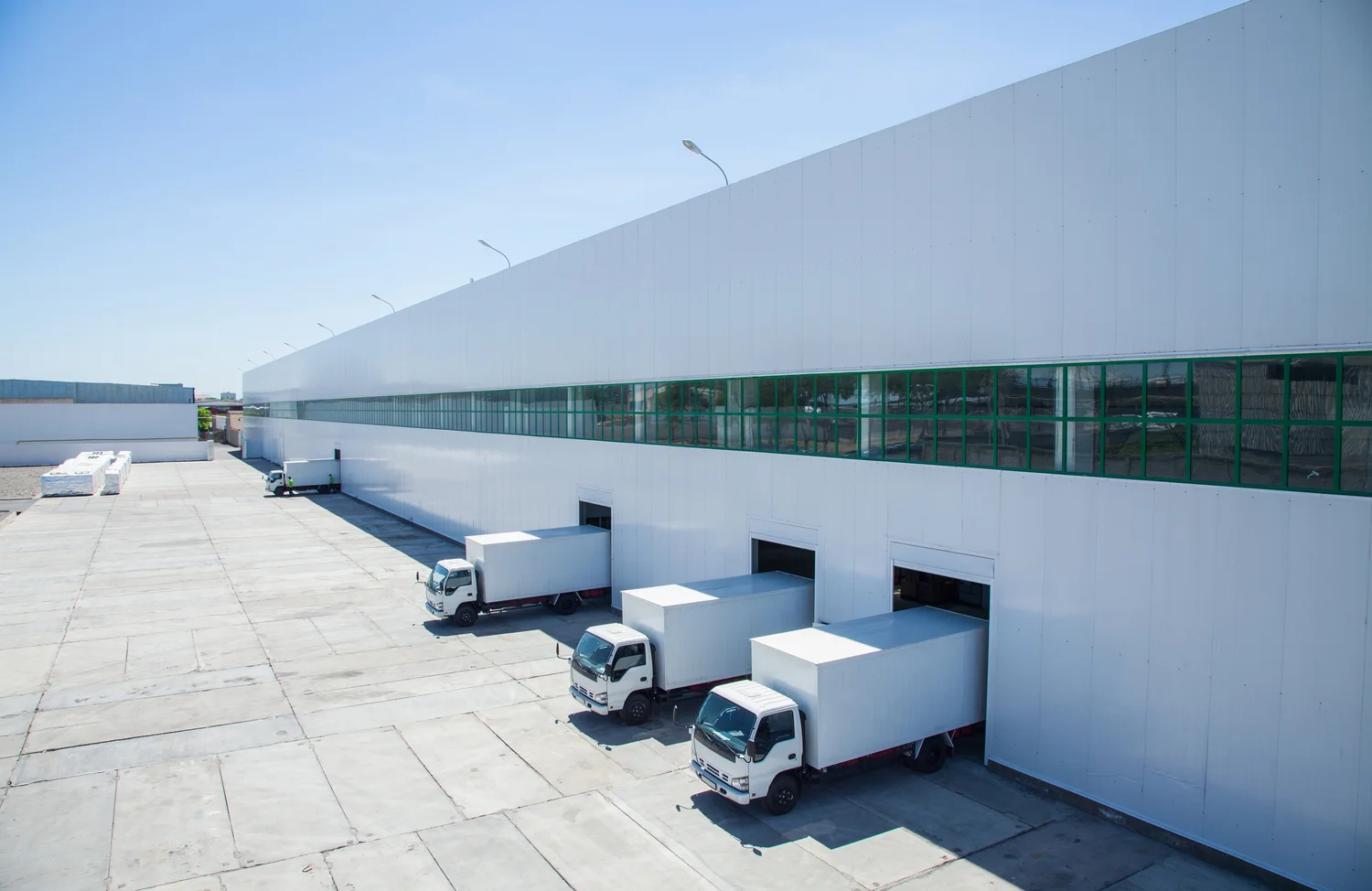Freight forwarding warehouse with loading docks and trucks ready for cargo transportation